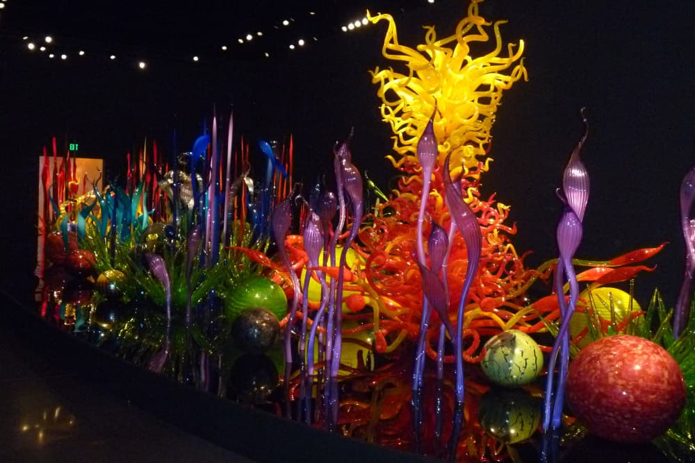 Interior gallery with dramatically lit large-scale glass installations