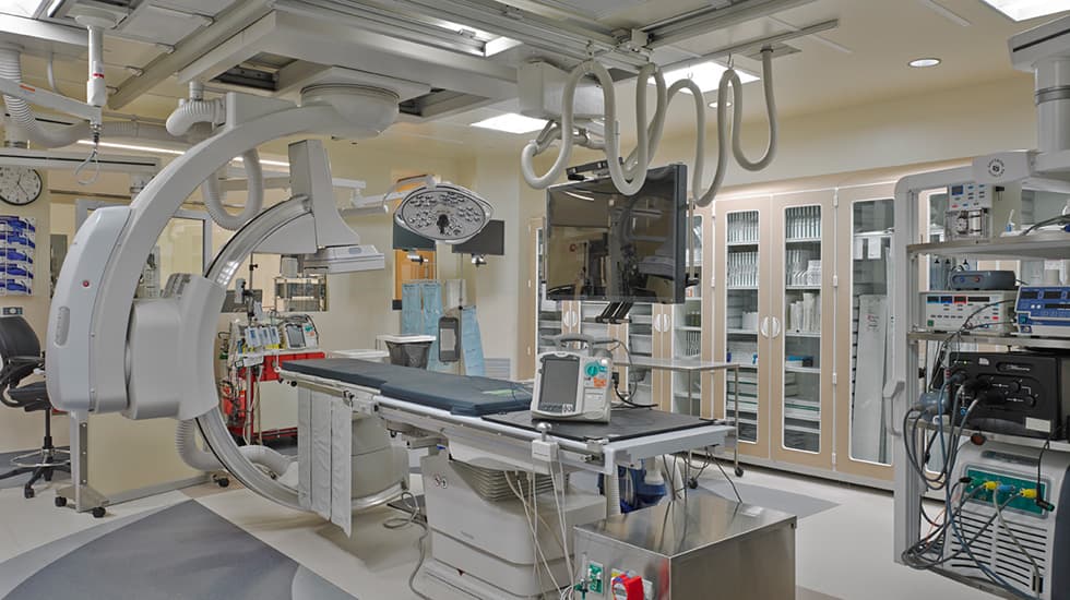 Cardiac catheterization lab with ceiling-mounted imaging boom and isolated power